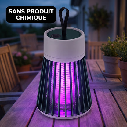 Lampe anti-moustique UV allumée sur une table de jardin à la tombée de la nuit