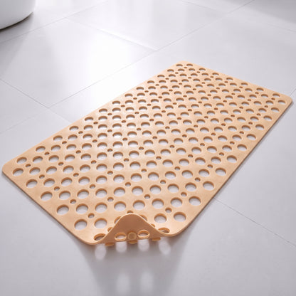 Tapis de douche antidérapant beige à trous et ventouses, posé à plat sur un sol carrelé