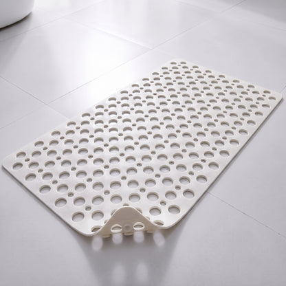 Tapis de douche antidérapant blanc à trous et ventouses, posé à plat sur un sol carrelé