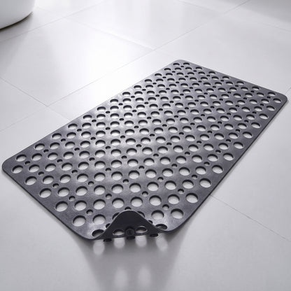 Tapis de douche antidérapant gris à trous et ventouses, posé à plat sur un sol carrelé