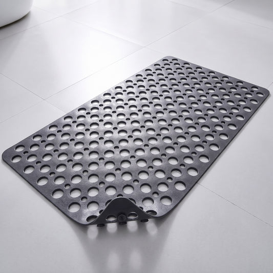 Tapis de douche antidérapant gris à trous et ventouses, posé à plat sur un sol carrelé