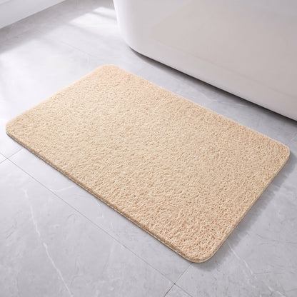 Tapis de bain antidérapant beige à boucles, posé à plat devant une baignoire