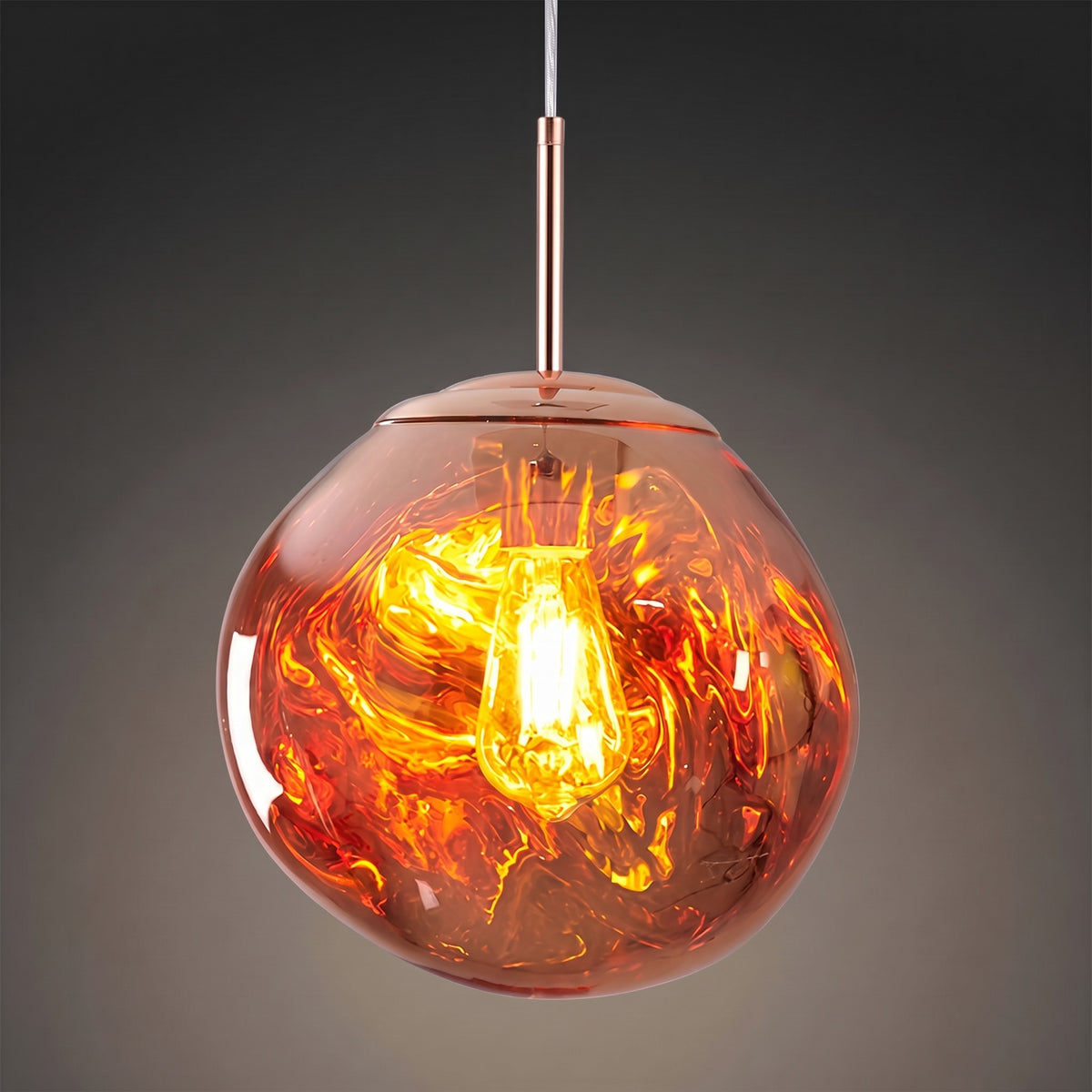 Suspension design à globe effet lave or rose allumée, tige or rose, sur fond gris anthracite