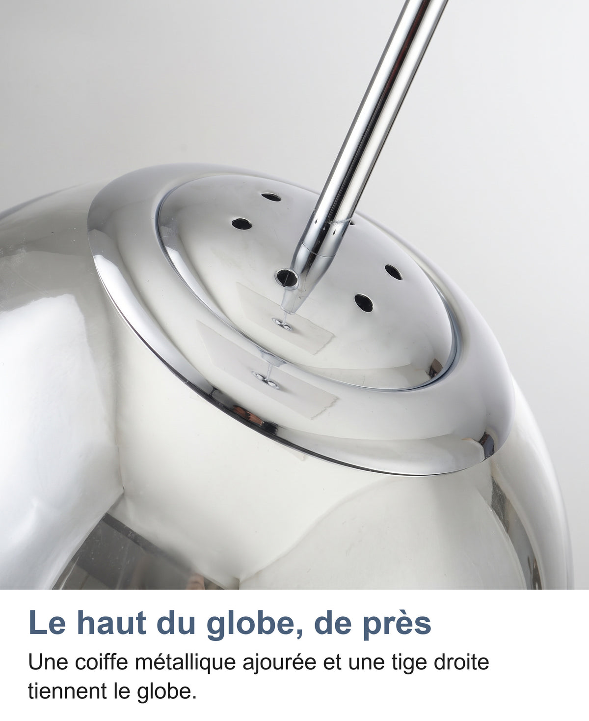 Gros plan sur la coiffe chromée ajourée et la tige en haut du globe