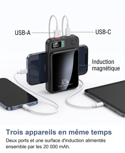 La batterie externe charge trois appareils: un téléphone par induction magnétique au dos et deux câbles branchés côte à côte en USB-A et USB-C sur le bord supérieur
