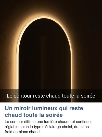Miroir cintré allumé le soir dans une pièce sombre, contour chaud continu