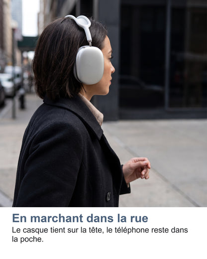 En marchant dans la rue. Le casque tient sur la tête, le téléphone reste dans la poche.