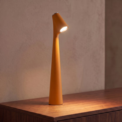 Lampe sans fil rechargeable orange en aluminium mat allumée sur une console en noyer, tête inclinée tournée vers l'objectif