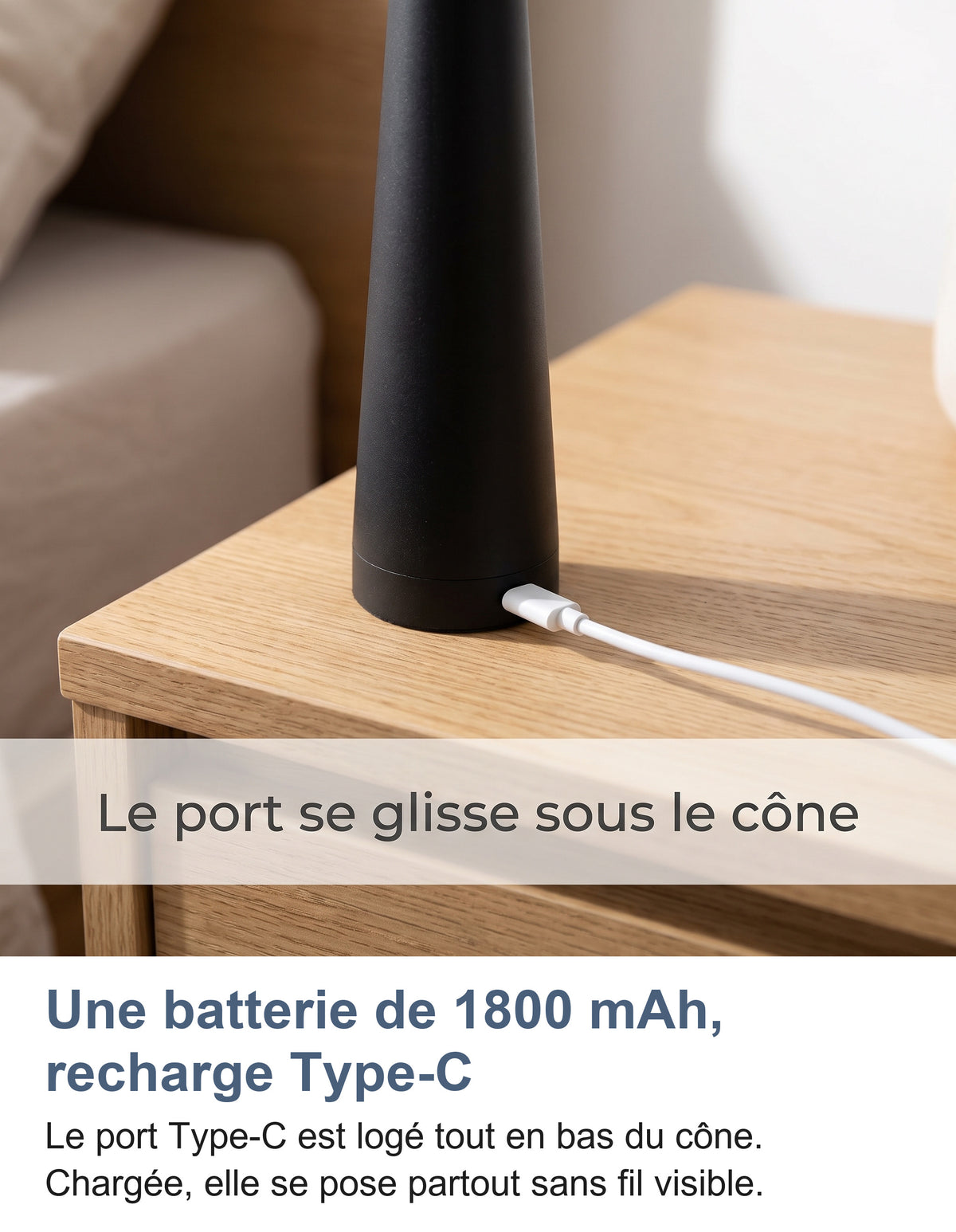 Port Type-C en bas du cône d'une lampe noire posée sur une table de chevet