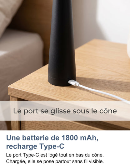 Port Type-C en bas du cône d'une lampe noire posée sur une table de chevet