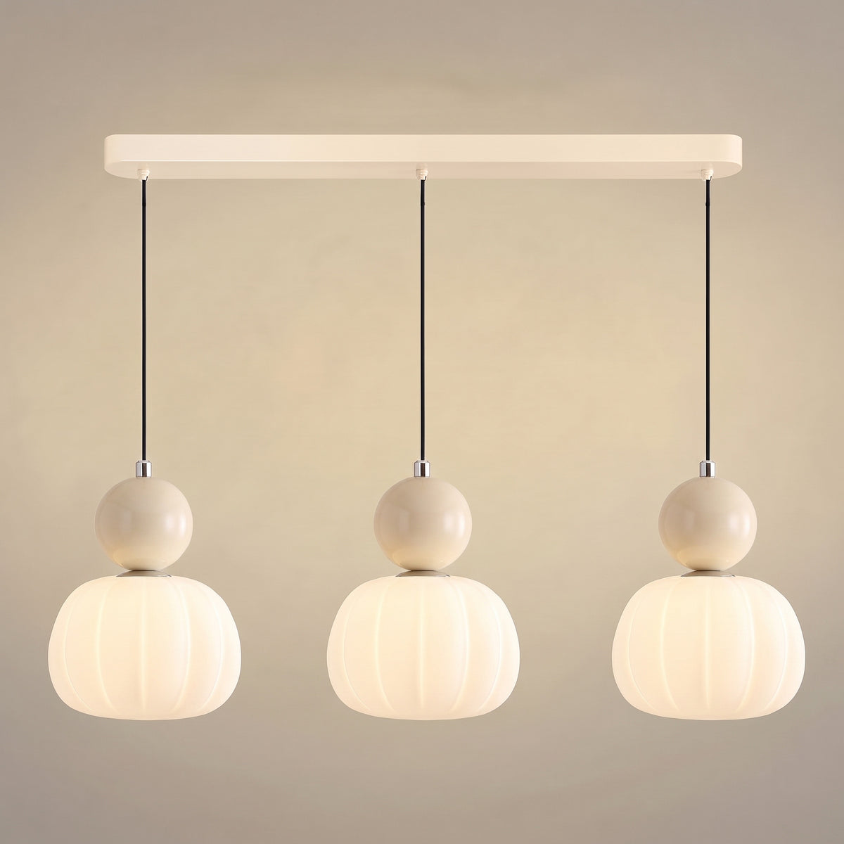Suspension vintage trois têtes sur barre crème, sphères crème sur abat-jour nervurés en opaline allumés
