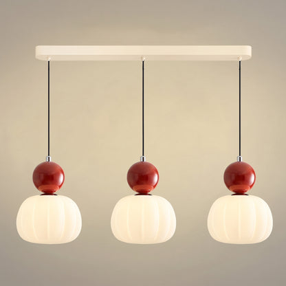 Suspension vintage trois têtes sur barre crème, sphères rouges sur abat-jour nervurés en opaline allumés