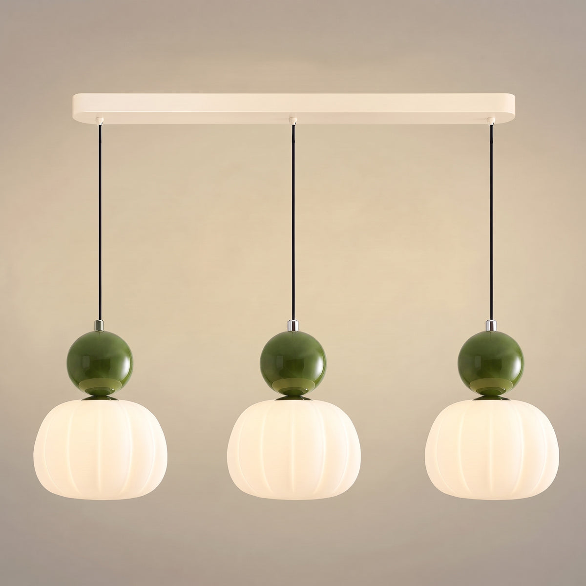 Suspension vintage trois têtes sur barre crème, sphères vertes sur abat-jour nervurés en opaline allumés
