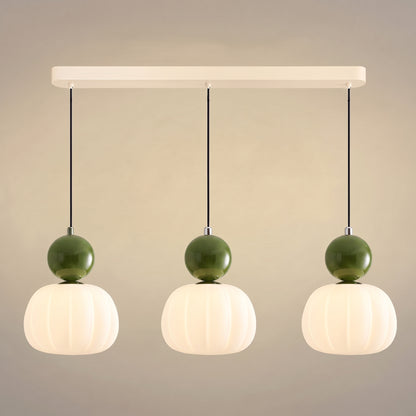 Suspension vintage trois têtes sur barre crème, sphères vertes sur abat-jour nervurés en opaline allumés