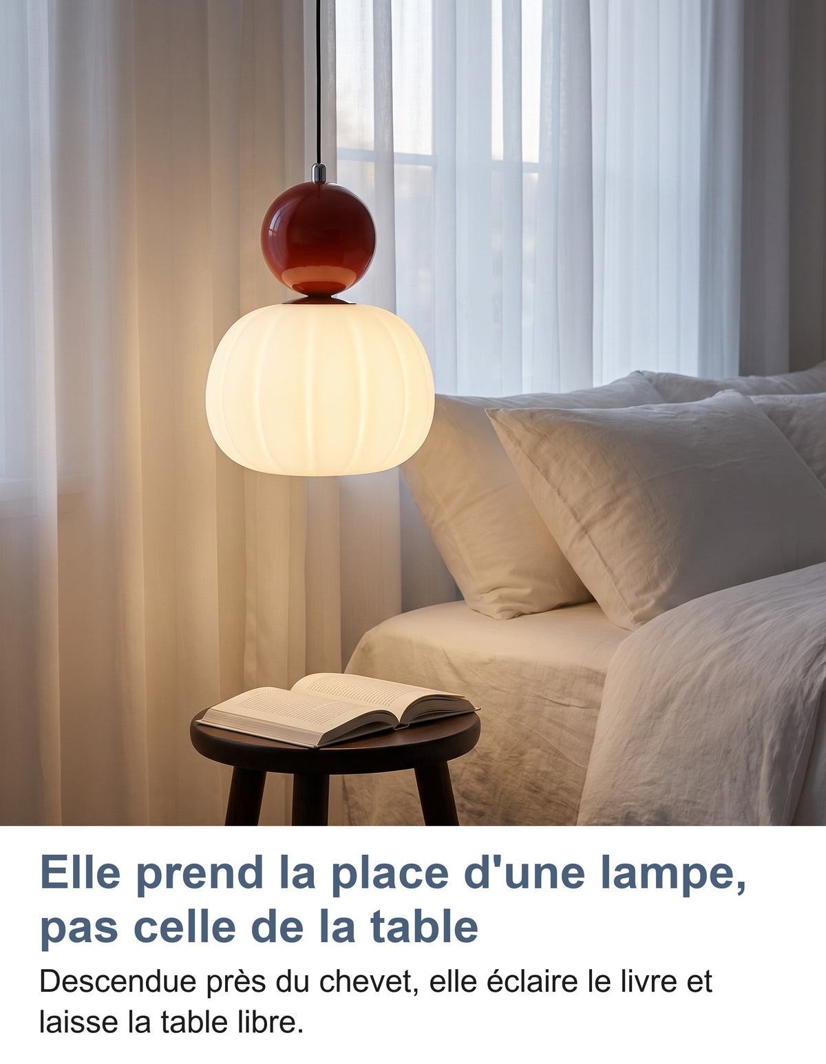 Suspension à sphère rouge allumée près d'un lit, au-dessus d'un tabouret et d'un livre ouvert