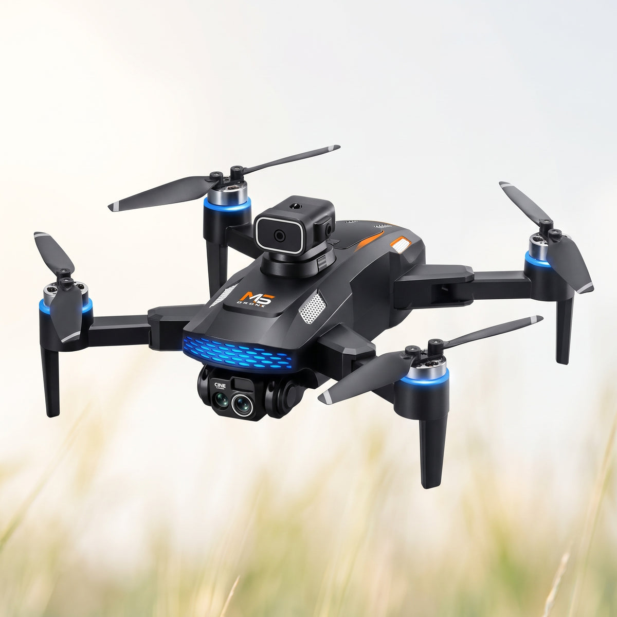 Drone pliable noir aux bras dépliés, vu de trois quarts devant un fond d'herbe et de ciel