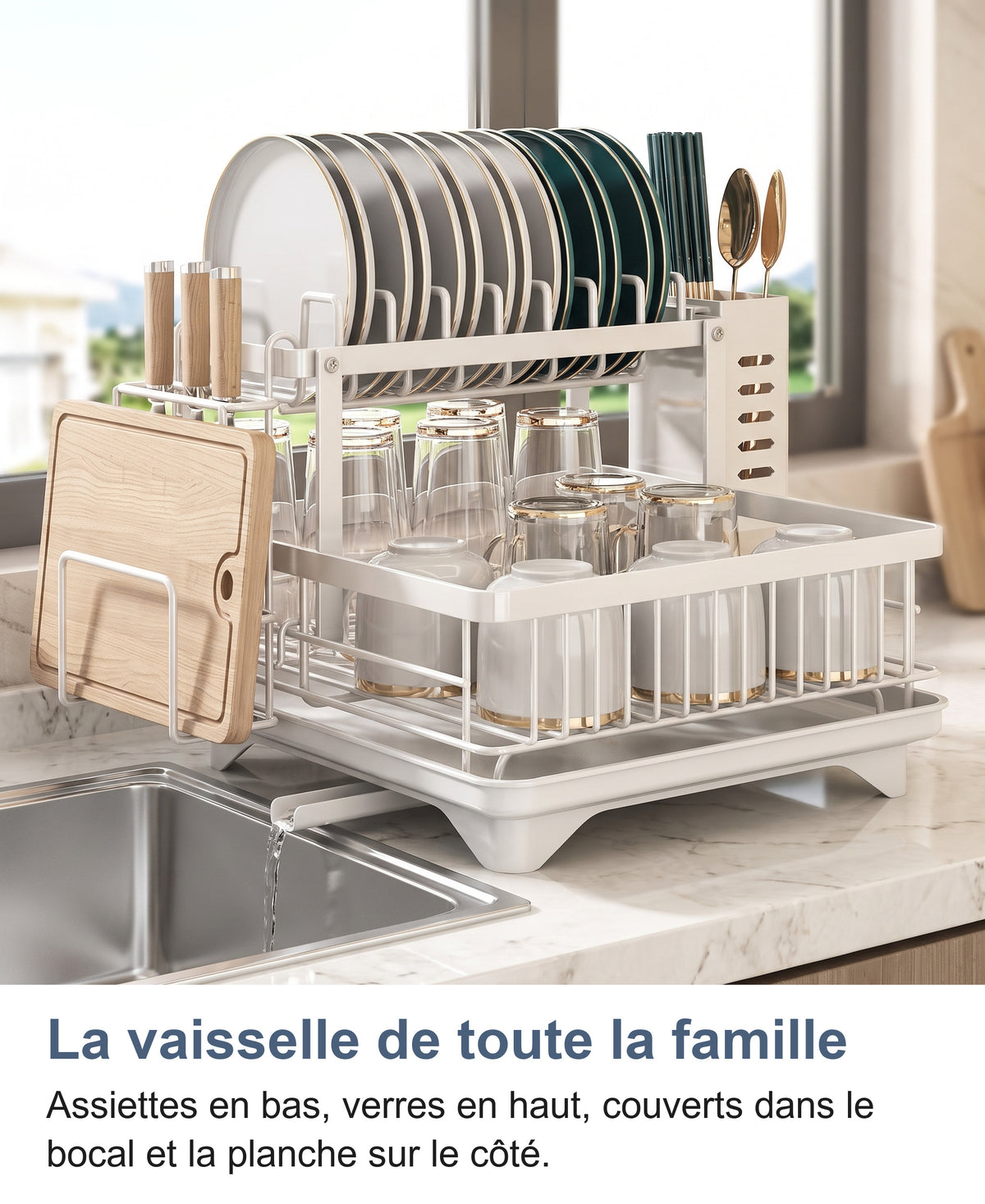 Égouttoir blanc 2 niveaux complet chargé près d'un évier, assiettes en haut, verres en bas, planche et couverts sur le côté
