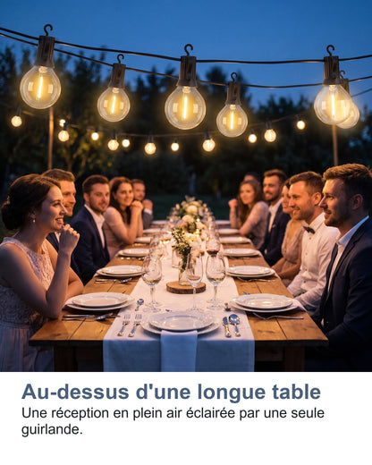 Au-dessus d'une longue table Une réception en plein air éclairée par une seule guirlande.