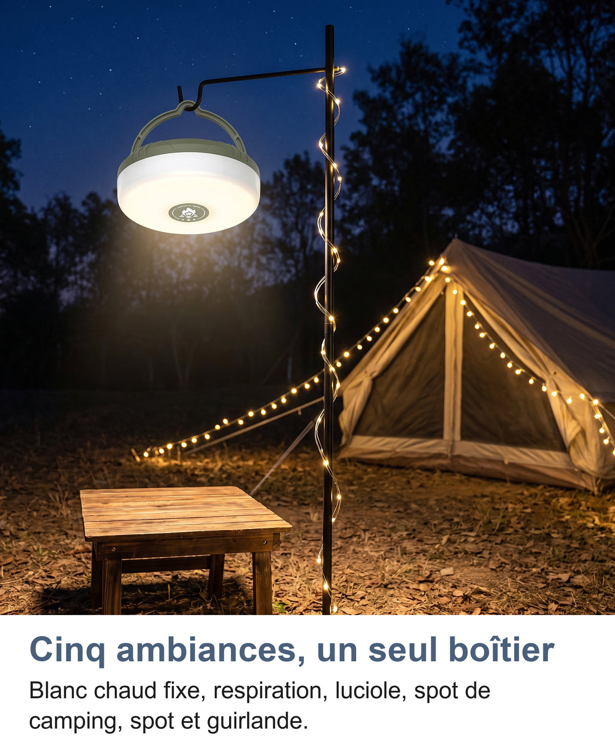 Boîtier suspendu par sa poignée à un mât la nuit au campement, guirlande blanc chaud enroulée sur le mât et tendue jusqu'à la tente