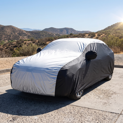 Voiture recouverte garée en plein soleil, le dessus argenté de la housse renvoie la lumière