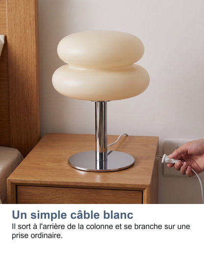 Le câble blanc de la lampe branché à une prise murale