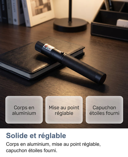 Pointeur laser posé sur un carnet en cuir sur un bureau, trois cartes d'atouts