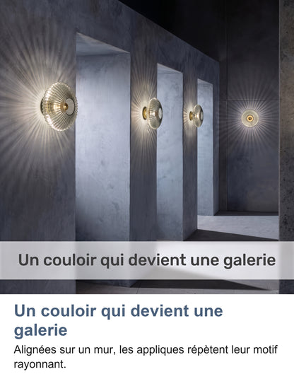 Quatre appliques en verre allumées en ligne dans un couloir en béton