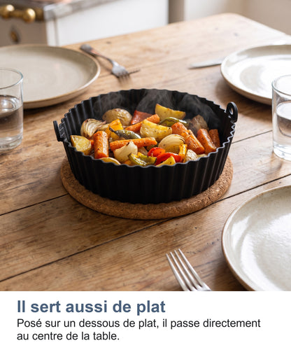 Le moule posé sur un dessous de plat au centre de la table, rempli de légumes
