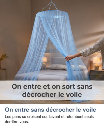 Une main écarte l'avant croisé d'une moustiquaire bleue pour entrer dans le lit