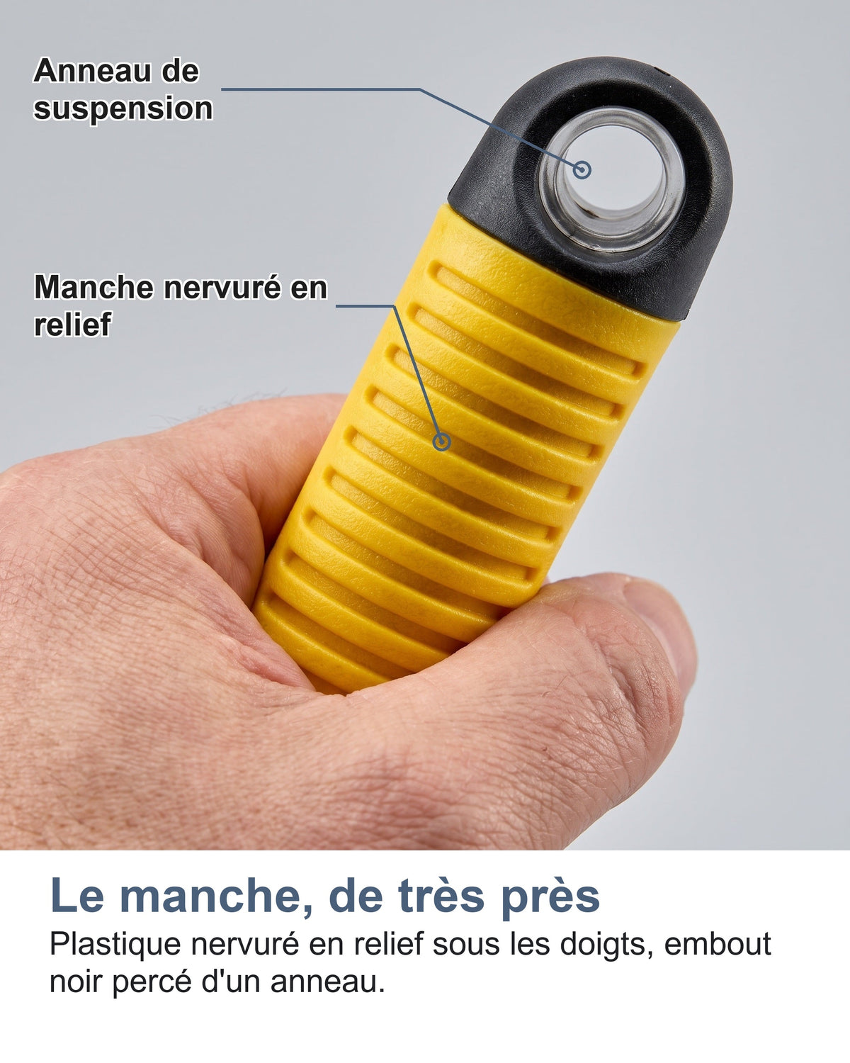 Le manche, de très près Plastique nervuré en relief sous les doigts, embout noir percé d'un anneau.