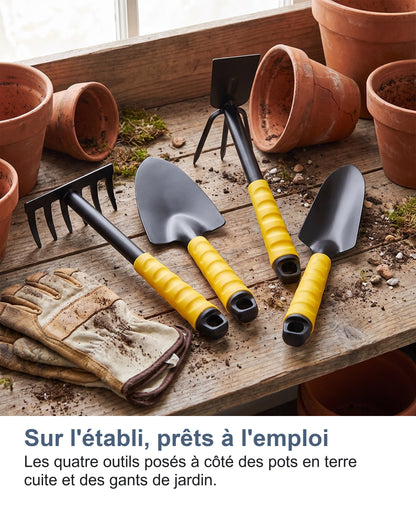Sur l'établi, prêts à l'emploi Les quatre outils posés à côté des pots en terre cuite et des gants de jardin.