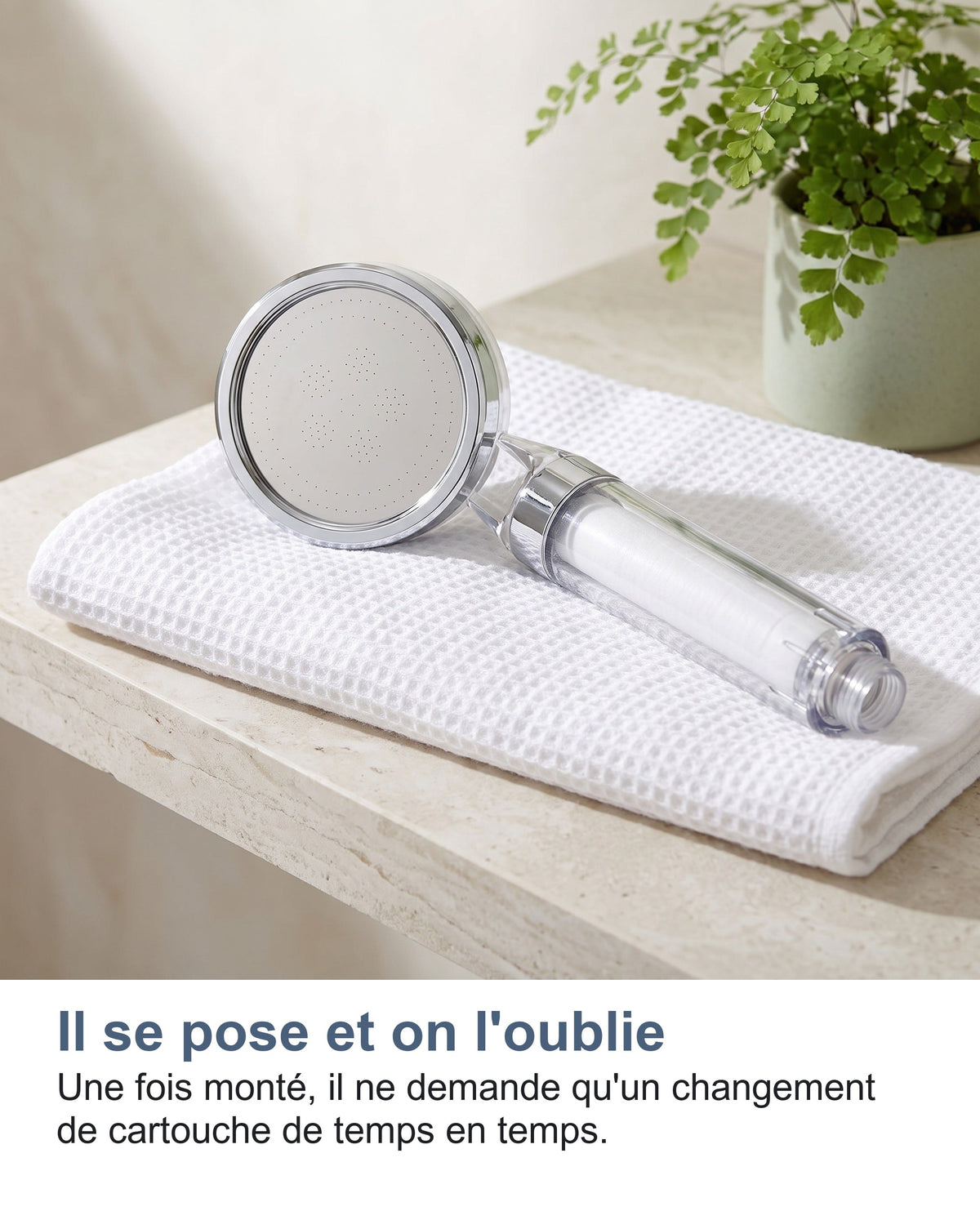 Le pommeau de douche filtrant posé sur une serviette