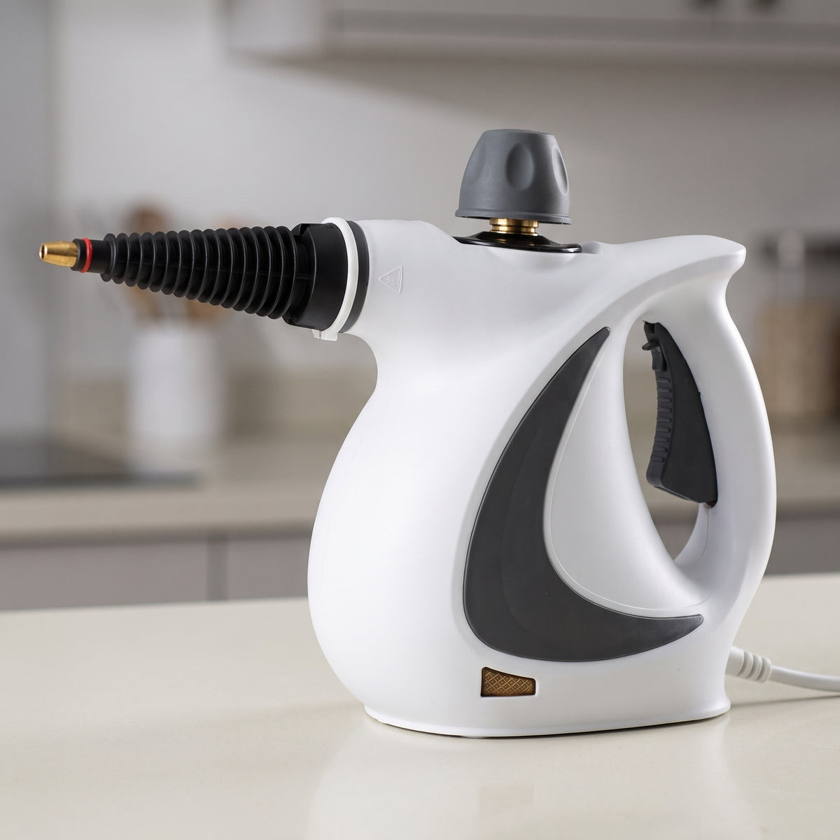 Nettoyeur vapeur à main blanc avec rallonge nervurée, posé sur un plan de travail de cuisine