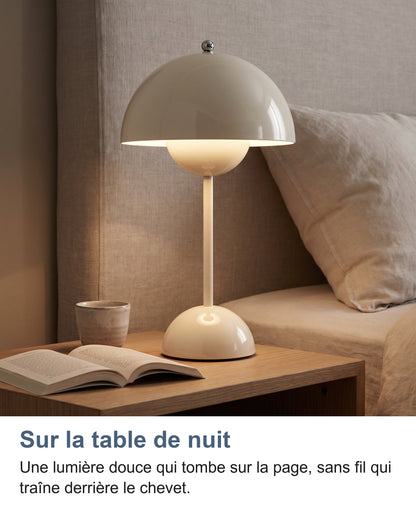 Lampe blanche allumée sur une table de chevet près d'un livre ouvert