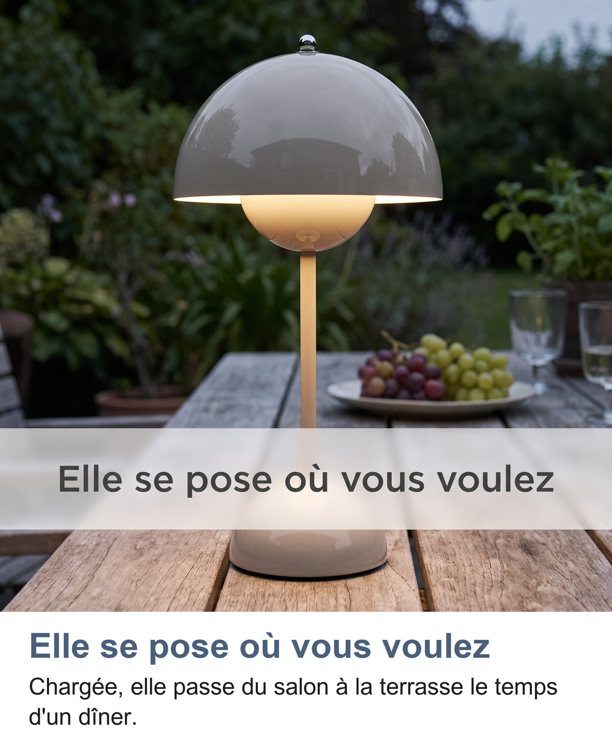 Lampe grise allumée sur une table de terrasse au crépuscule