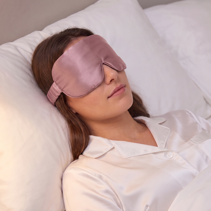 Masque de nuit en soie rose porté au lit